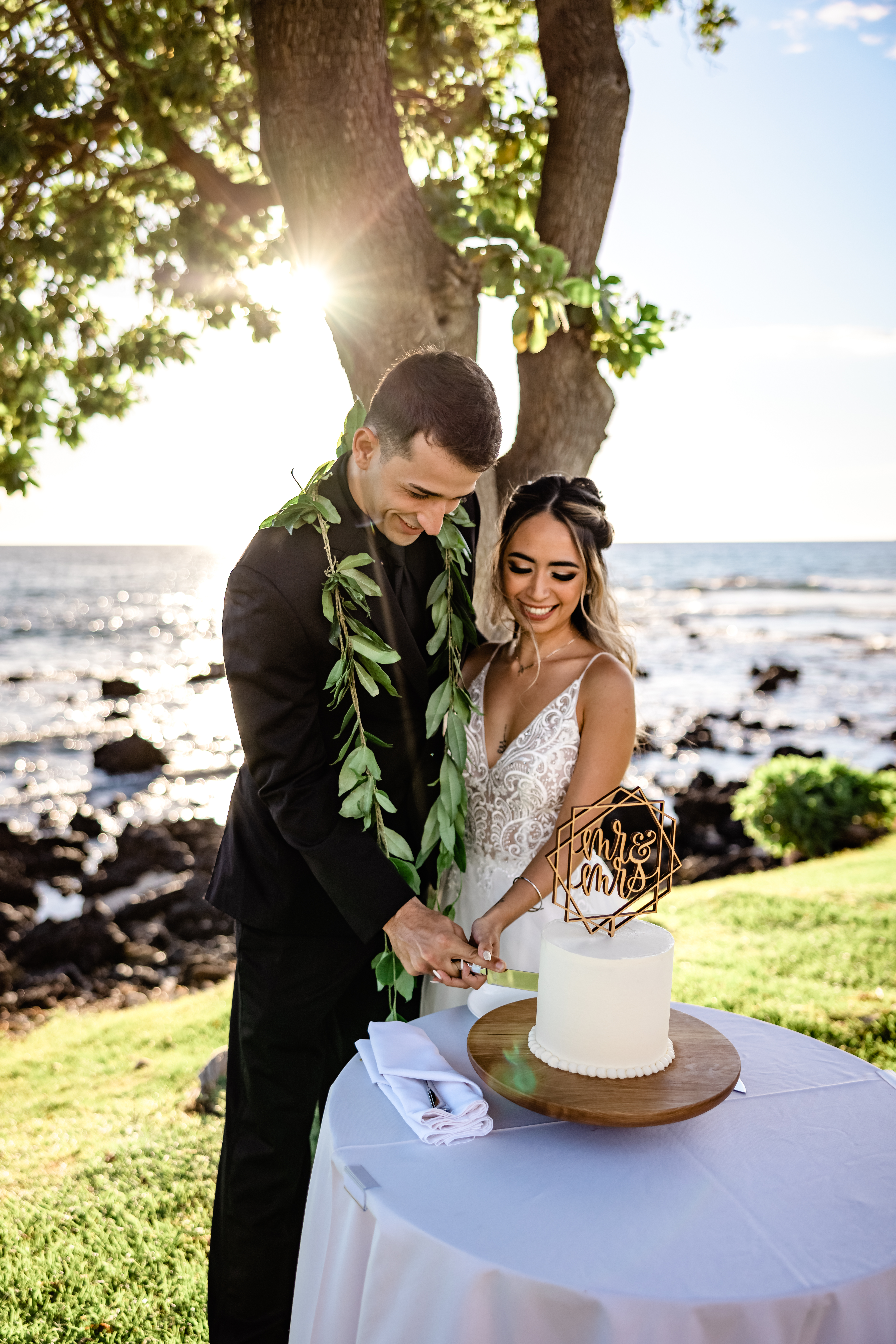 Bride and Groom cut wedding cake by the ocean after Hawaii elopement